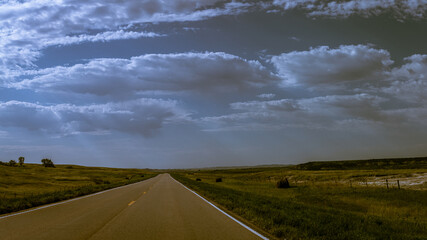 Panorama shot of road in wrinkled landscape in Badlands national park after sunrise in america