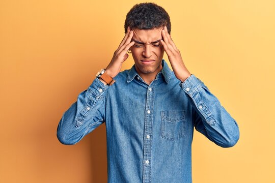 Young african amercian man wearing casual clothes with hand on head, headache because stress. suffering migraine.
