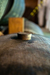 Cork close up, old porto lodge with rows of oak wooden casks for slow aging of fortified ruby or tawny porto wine in Vila Nova de Gaia, Portugal