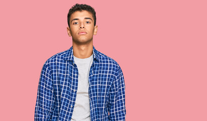 Young handsome african american man wearing casual clothes relaxed with serious expression on face. simple and natural looking at the camera.