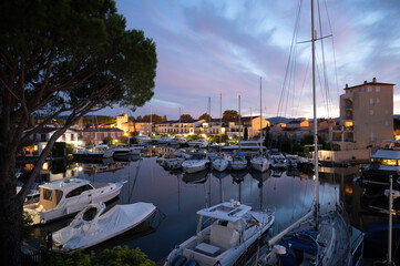 Fototapeta na wymiar View on houses, roofs, canals and boats in Port Grimaud, Var, Provence, France during sunset