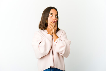 Young mixed race woman thoughtful looking to a copy space covering mouth with hand.