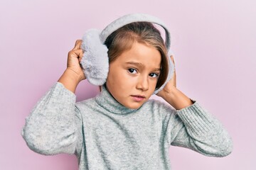 Little beautiful girl wearing fluffy earmuff skeptic and nervous, frowning upset because of problem. negative person.