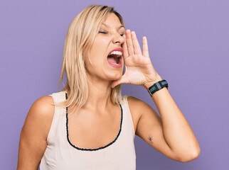 Middle age caucasian woman wearing casual clothes shouting and screaming loud to side with hand on mouth. communication concept.