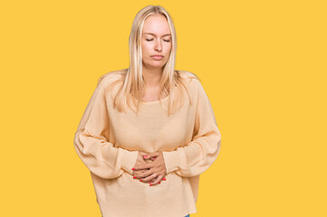 Young blonde girl wearing casual clothes with hand on stomach because indigestion, painful illness...