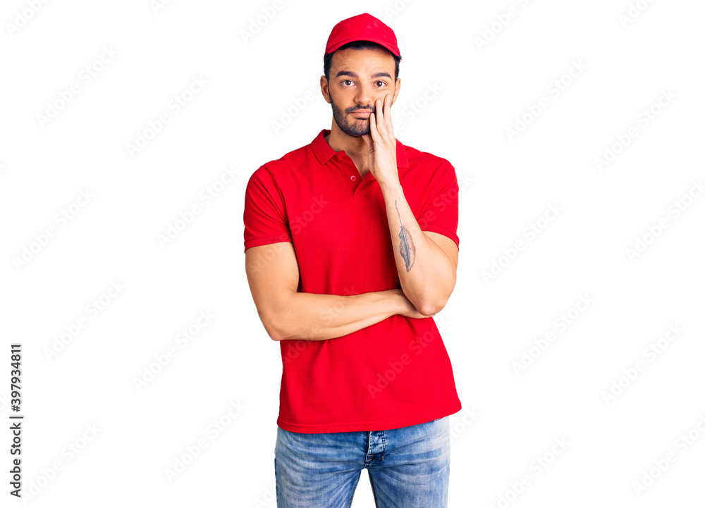 Wall mural young handsome hispanic man wearing delivery courier uniform thinking looking tired and bored with d