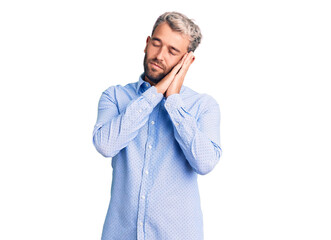 Young handsome blond man wearing elegant shirt sleeping tired dreaming and posing with hands together while smiling with closed eyes.