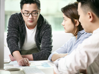 team of three asian business men and woman meeting in office