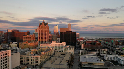  Aerial view of American city at sunset. Modern buildings, skyscrapers. Cloudy sky, cityscape....