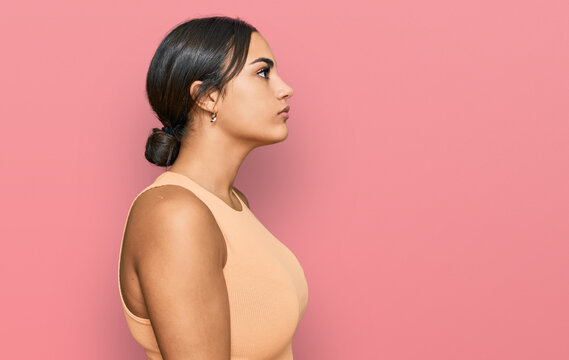 Young brunette woman wearing casual clothes looking to side, relax profile pose with natural face with confident smile.