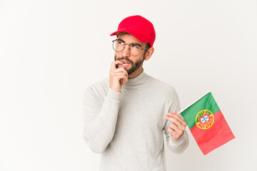Young hispanic mixed race woman holding a portugal flag relaxed thinking about something looking at a copy space.