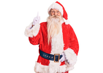 Old senior man with grey hair and long beard wearing traditional santa claus costume showing and pointing up with finger number one while smiling confident and happy.