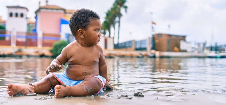 Adorable african american toddler sitting at the beach.