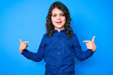Cute hispanic child with long hair wearing casual clothes looking confident with smile on face,...