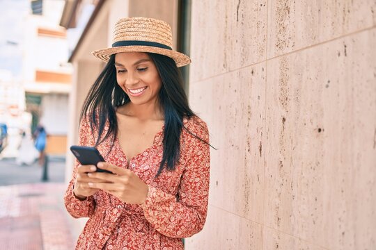 Young african american tourist woman on vacation smiling happy using smartphone at the city.