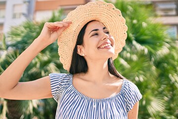 Young latin tourist girl on vacation smiling happy at the city.