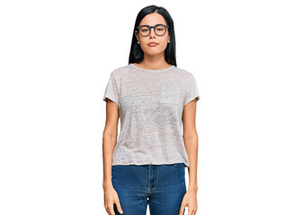 Obraz premium Beautiful young woman wearing casual clothes and glasses with serious expression on face. simple and natural looking at the camera.