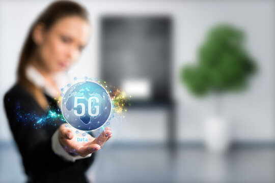 businesswoman presenting a virtual world map with message 5G in front of an ofice background