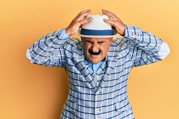 Mature middle east man with mustache wearing vintage and elegant fashion style suffering from headache desperate and stressed because pain and migraine. hands on head.