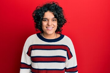 Young hispanic woman with curly hair wearing casual winter sweater with a happy and cool smile on face. lucky person.