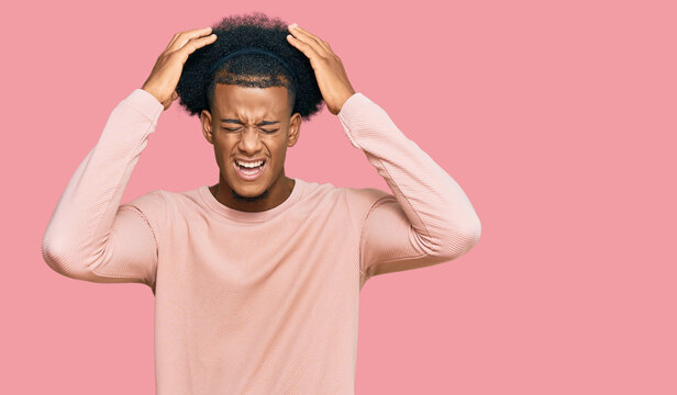African american man with afro hair wearing casual clothes suffering from headache desperate and stressed because pain and migraine. hands on head.