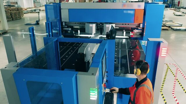 Male operator is working with a machine in the refrigeration factory facility.
