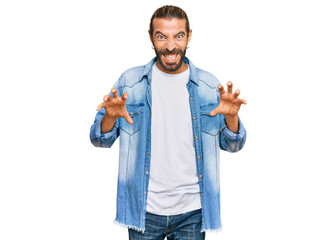 Attractive man with long hair and beard wearing casual denim jacket smiling funny doing claw...