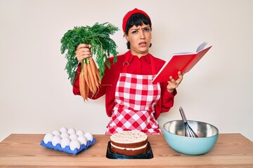 Beautiful brunettte woman cooking carrot cake reading recipes book clueless and confused...
