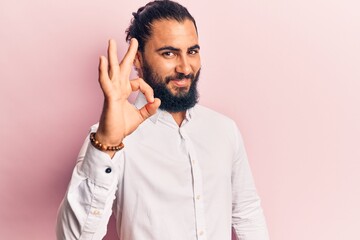 Young arab man wearing casual clothes smiling positive doing ok sign with hand and fingers. successful expression.