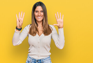 Young woman wearing casual clothes showing and pointing up with fingers number nine while smiling...