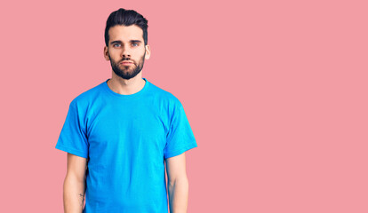 Young handsome man with beard wearing casual t-shirt with serious expression on face. simple and natural looking at the camera.