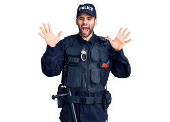 Young handsome man with beard wearing police uniform celebrating mad and crazy for success with...