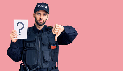 Young handsome man with beard wearing police uniform holding question mark with angry face, negative sign showing dislike with thumbs down, rejection concept