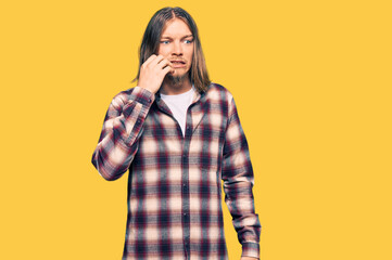 Handsome caucasian man with long hair wearing hipster shirt looking stressed and nervous with hands...