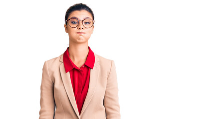Young beautiful woman wearing business shirt and glasses puffing cheeks with funny face. mouth...
