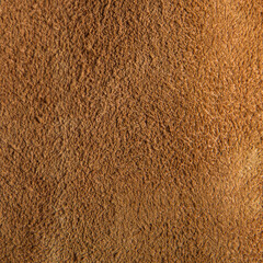 leather grunge background: an old piece of tough camel skin, with scuffs, spots, scars