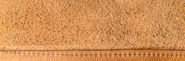 leather grunge background: an old piece of tough camel skin, with scuffs, spots, scars, stitched...