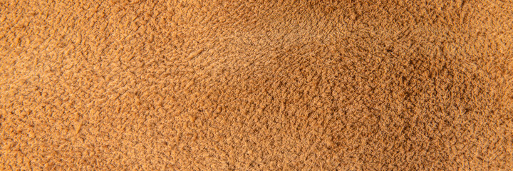 leather grunge background: an old piece of tough camel skin, with scuffs, spots, scars
