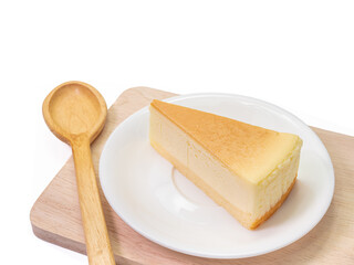 The close up of sliced yummy cheesecake bakery sweet dessert and wooden spoon on wood cutting board isolated on white background.