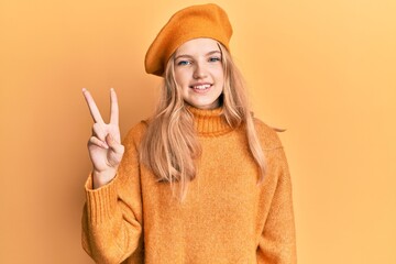 Beautiful young caucasian girl wearing french look with beret showing and pointing up with fingers number two while smiling confident and happy.