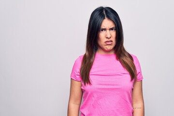 Fototapeta premium Young beautiful brunette woman wearing casual pink t-shirt standing over white background skeptic and nervous, frowning upset because of problem. Negative person.
