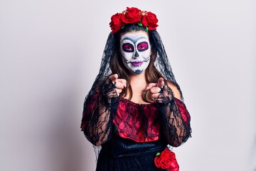 Young woman wearing day of the dead costume over white pointing to you and the camera with fingers, smiling positive and cheerful