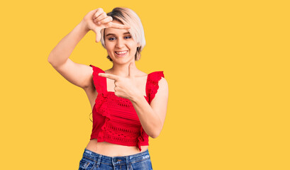 Young beautiful blonde woman wearing casual clothes smiling making frame with hands and fingers with happy face. creativity and photography concept.