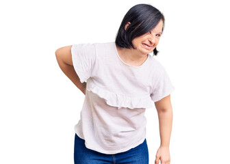 Brunette woman with down syndrome wearing casual white tshirt suffering of backache, touching back with hand, muscular pain