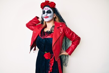 Obraz premium Woman wearing day of the dead costume over white suffering of neck ache injury, touching neck with hand, muscular pain