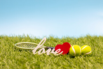 Tennis ball with love word on green grass