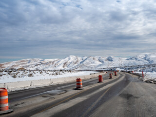 Desert snowfall along a highway with road construction.