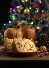 Delicious slice of Panettone with candied fruit on the table on a blurred background