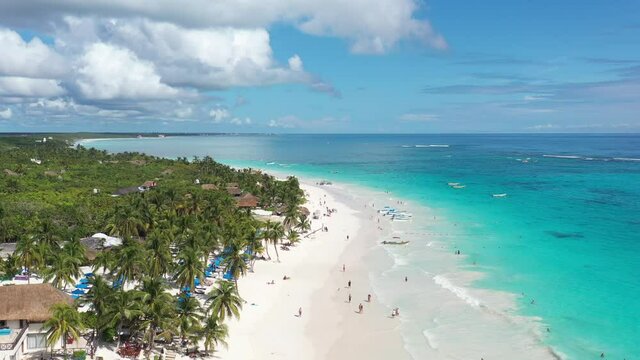 Espectacular vista a&eacute;rea sobre Playa Para&iacute;so, con muchos turistas caminando sobre la playa y ba&ntilde;&aacute;ndose en el mar, en Tulum, M&eacute;xico.
