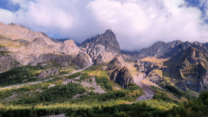 Rocky mountains view in summer day with white clouds in blue sky